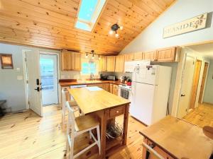 a kitchen with a wooden table and a white refrigerator at HOLIDAY COVE - LIMIT 8 villa in Naples