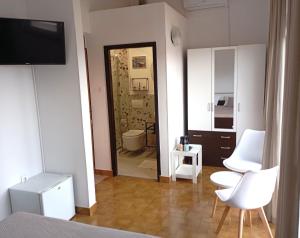 a room with two white chairs and a bathroom at Rooms Helena in Krk +46 photos