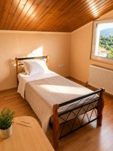a bedroom with a bed and a window at Charming Apartment with Sea View in Néa Seléfkeia