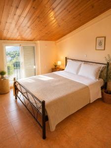 a bedroom with a large bed with a wooden ceiling at Charming Apartment with Sea View in Néa Seléfkeia