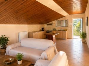 a living room with a wooden ceiling and a kitchen at Charming Apartment with Sea View in Néa Seléfkeia