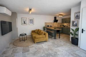 a living room with a couch and a kitchen at Le Petit Chalet in Crolles +12 photos