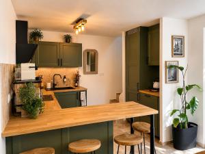 a kitchen with green cabinets and a wooden counter top at Le Petit Chalet in Crolles