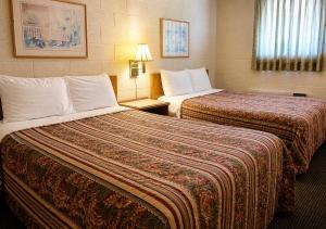 a hotel room with two beds in a room at Skyline Motel Bartlesville Hwy 75 in Bartlesville