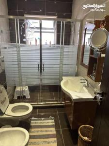a bathroom with a toilet and a sink and a shower at عمان - ضاحية النخيل in Amman +15 photos