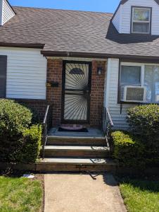 a front door of a house with stairs at Isa-e Home Stay in Hempstead