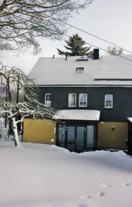 a house with a snow covered roof at Apfeltraum-Erzgebirge in Neuhausen