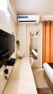 a living room with a large television and a bed at Blue Mans Rooms - Near Prem Mandir & ISKCON in Vrindāvan