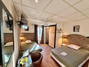 a small room with a bed and a desk in it at Hôtel Paul Riquet in Béziers +127 photos
