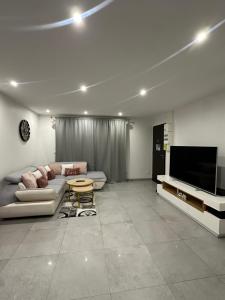 a living room with a couch and a flat screen tv at Suite Jacuzzi Giverny Paris in Freneuse