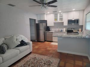 a living room with a couch and a kitchen at Manatee River Bungalow - 4 in Bradenton