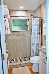 a small bathroom with a toilet and a window at Manatee River Bungalow - 4 in Bradenton
