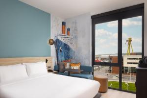 a hotel room with a bed and a window at Aloft by Marriott Belfast Titanic Quarter in Belfast +89 photos