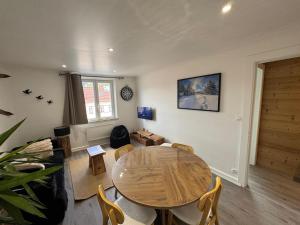 a living room with a wooden table and chairs at L'ANTRE Deux LACS avec parking et garage in Xonrupt-Longemer