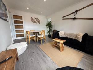 a living room with a couch and a table at L'ANTRE Deux LACS avec parking et garage in Xonrupt-Longemer