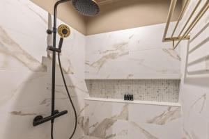 a shower in a bathroom with white marble at Bali Suites - Sanur suite in Willemstad