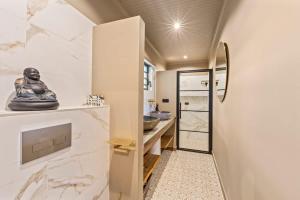 a bathroom with white marble walls and a walk in shower at Bali Suites - Sanur suite in Willemstad