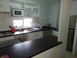 a kitchen with a black counter top and a microwave at Condominio Lomas de Papudo I in Papudo