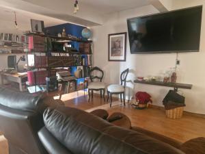 a living room with a couch and a flat screen tv at Casa del Horno in El Cinco de Mayo