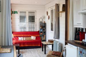 a living room with a red couch in a room at Container Maritime Montagne Noire in Fontiers-Cabardès