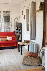 a living room with a red couch and a table at Container Maritime Montagne Noire in Fontiers-Cabardès