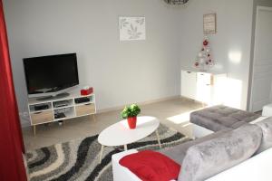 a living room with a couch and a tv at Gîte de Roches Hibou in Seigy