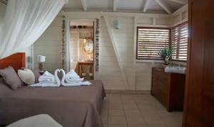 a bedroom with a bed with white towels on it at Villa Vigie in Deshaies