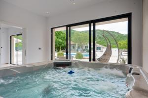a jacuzzi tub in a house with a slide at Villa Silentio Luxury with pool, jacuzzi & sauna in Podgora