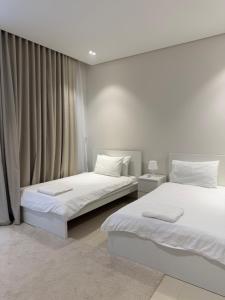 a bedroom with two beds and a window at Beach front 414 villa private pool in Muscat +5 photos