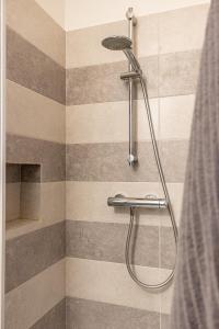 a shower in a bathroom with a striped wall at Al Castello - fresco e ben isolato appartamento in Calolziocorte
