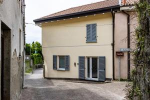 a building with blue shutters on a street at Al Castello - fresco e ben isolato appartamento in Calolziocorte +34 photos
