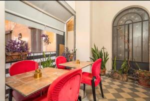 a dining room with red chairs and a table at DS Apartment in Catania