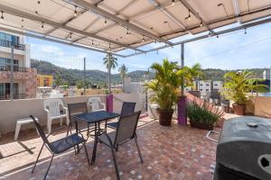 a patio with a table and chairs on a roof at Bungalows Yeah Los Ayala in Los Ayala