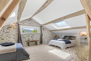 a attic bedroom with two beds and a window at Les Gîtes Du Saro in Chabestan