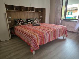 a bedroom with a bed with a colorful blanket and pillows at Nido Ticino in Bernate Ticino +16 photos
