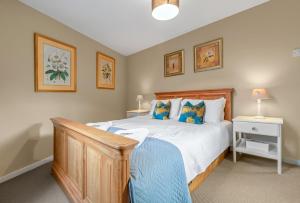 a bedroom with a large bed with a wooden headboard at Pools Cottages - Warwick Luxury Countryside Near NEC in Kenilworth