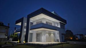 a large white house with the number seven on it at Pearl Luxury Suites in Paralia Dionysiou