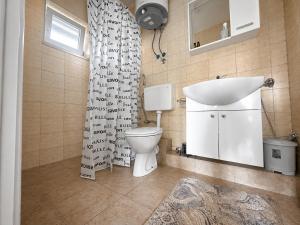 a bathroom with a toilet and a sink and a shower curtain at Green House Cuprija in Stolac