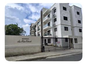 a white building with a fence in front of it at Beautiful View Apartment in San Pedro de Macorís