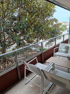 a balcony with two chairs and a tree at La casa en la playa in Rota +63 photos