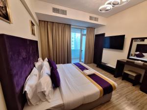 a bedroom with a bed with a desk and a television at Aspire Tower in Manama +56 photos
