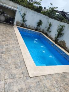 a blue swimming pool next to a wall at Beautiful View Apartment in San Pedro de Macorís