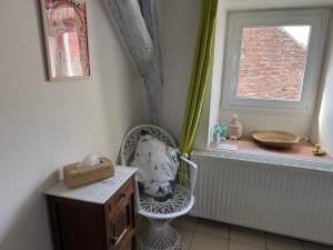 a room with a chair and a window at L eau douce in Ménétréol-sous-Sancerre
