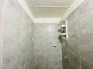 a bathroom with a shower with a tiled wall at Casa Edi Hostal Santa Marta in Santa Marta +10 photos
