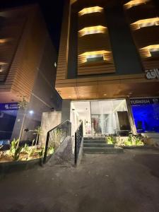 a building with stairs in front of it at night at شقق كورال الفندقية in Buraydah