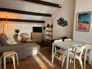 a living room with a couch and a table and chairs at Azurea in Saint-Cyr-sur-Mer