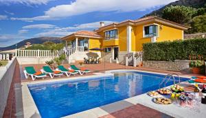 a villa with a swimming pool and a house at Villa Rosal in Oia