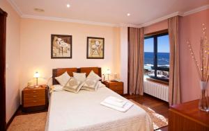a bedroom with a bed with a view of the ocean at Villa Rosal in Oia +16 photos