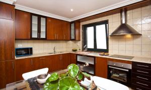 a kitchen with wooden cabinets and a table with chairs at Villa Rosal in Oia