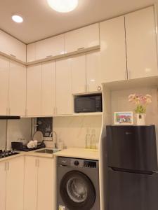 a kitchen with white cabinets and a washing machine at Bougainvillea Breeze in Male City
